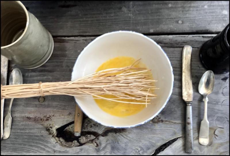 Eggs for hearth-baked cornbread are beaten with a birch-straw whisk at a recent Seaport Saturdays event hosted by the Lewes Historical Society. JACK CLEMONS PHOTO